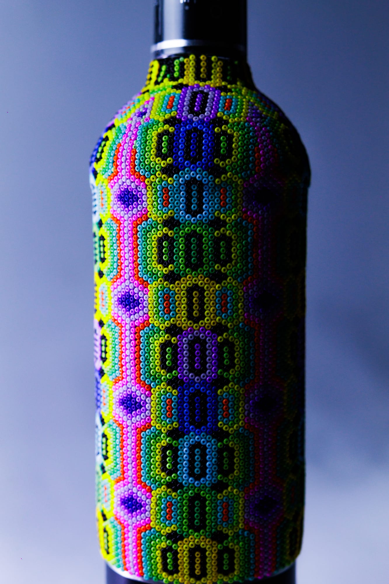 Botella con arte huichol en ángulo dramático