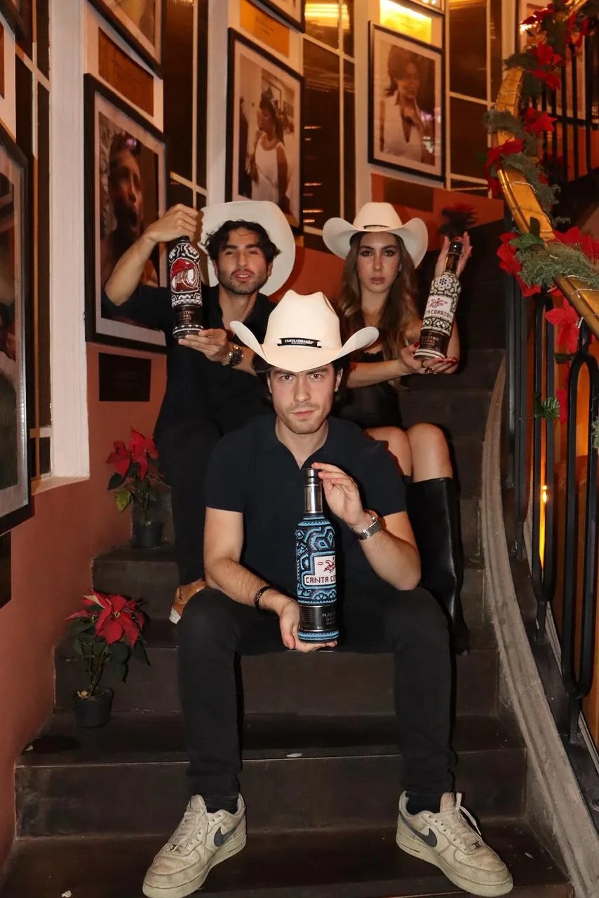 Trío con botellas en las escaleras